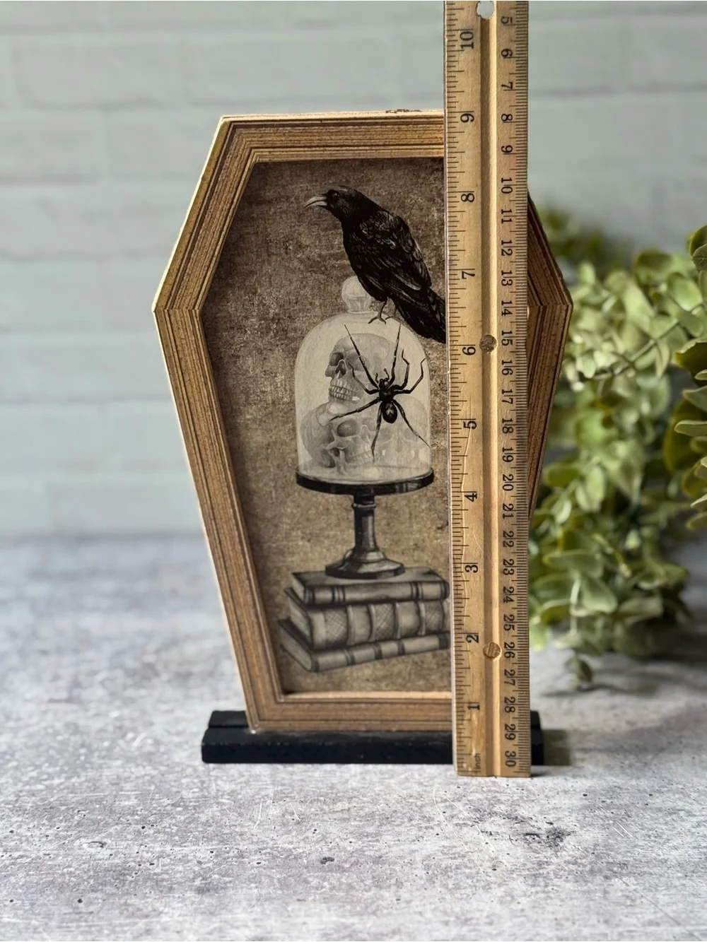 Coffin Shaped Halloween Decor with Crow, Skulls, Books, and Spider Illustration